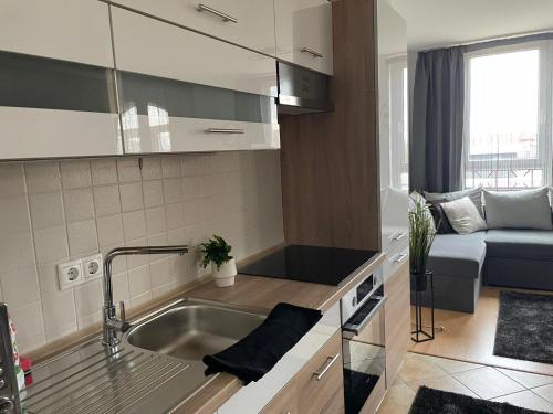 a small kitchen with a sink and a couch at Európa 20 Apartman in Bük