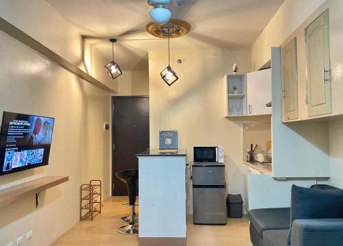 a living room with a couch and a kitchen with a tv at King Size Bed At the Heart Of the City in Cagayan de Oro