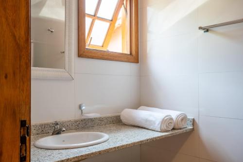 a bathroom with a sink and a mirror at Pousada Casalinda Camburi in Camburi