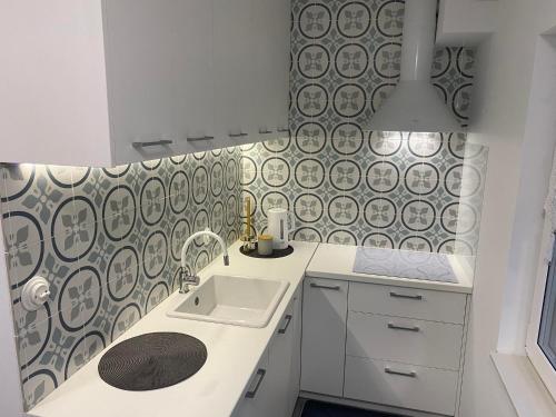 a kitchen with a sink and a patterned wall at Apartament in Władysławowo