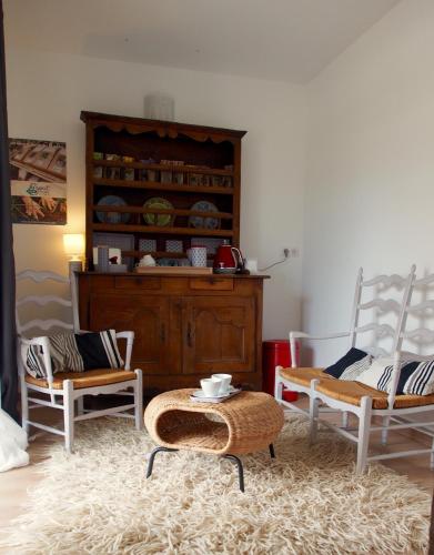 a living room with two chairs and a table at Transhumance & cie, Auberge, Appartements & SPA in Bedous