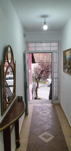 a hallway with a mirror and a door to a yard at Panos rooms 2 in Kalabaka