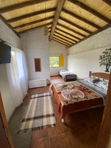 a large room with two beds in it at Chalé Boa Vista in Carrancas