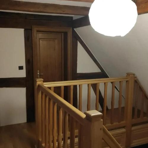 a hallway with a wooden staircase with a light at GITE AU PETIT RUISSEAU-Etage et combles-maison alsacienne 4 personnes 4 nuitées minimum in Langensoultzbach