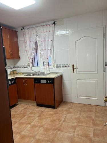 pusta kuchnia ze zlewem i drzwiami w obiekcie Casa duplex en chipiona w mieście Chipiona