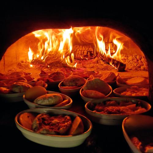 a fire oven with a bunch of food in it at Transhumance & cie, Auberge, Appartements & SPA in Bedous
