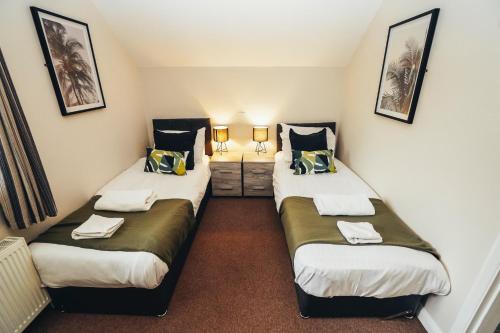 two twin beds in a room with two lamps at Cottages In Derbyshire - Apple Cottage in Belper