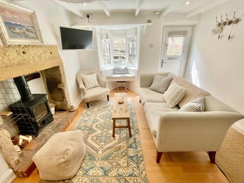 a living room with a couch and a fireplace at Normanby Cottage Runswick Bay in Runswick