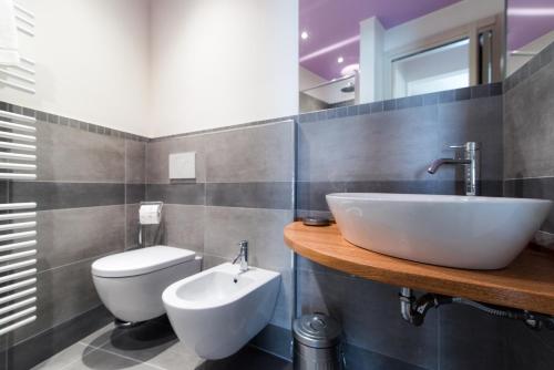 a bathroom with a white sink and a toilet at La casa dei tre pesci - Appartamento Lavarello in Torno