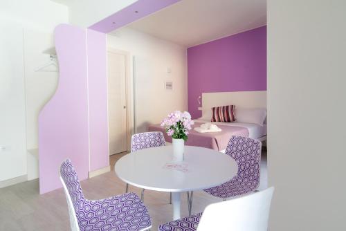 a dining room with purple walls and a white table and chairs at La casa dei tre pesci - Appartamento Lavarello in Torno