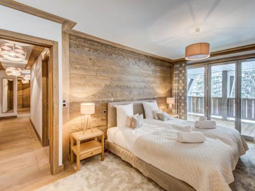 a bedroom with a large bed and a wooden wall at Appartement Courchevel 1550, 4 pièces, 6 personnes - FR-1-562-37 in Courchevel