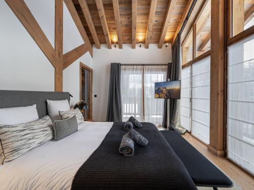 a bedroom with a large bed with shoes on it at Chalet neuf avec piscine, sauna et proche des pistes à Courchevel Village - FR-1-562-49 in Courchevel