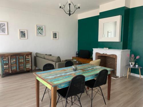 un salon avec une table et une cheminée dans l'établissement DOUAI 1 spacieux et joli appartement, à Douai