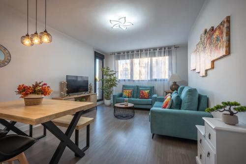 a living room with a blue couch and a table at Apartamento Estepona II in Estepona