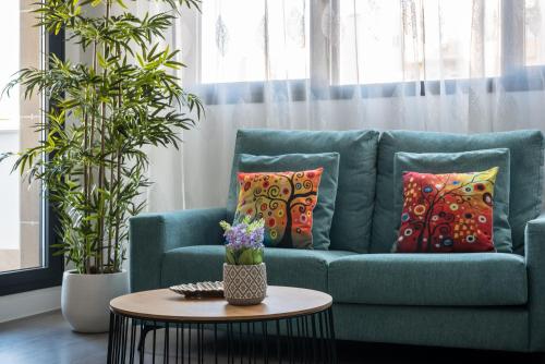 a blue couch with pillows and a table in a living room at Apartamento Estepona II in Estepona