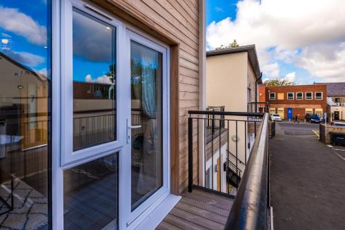 a balcony with a sliding glass door with a view of a street at Formby Village Apartments By Greenstay Serviced Accommodation - Perfect For SHORT & LONG STAYS - Couples, Friends, Families & Business Travellers All Welcome - Dog Friendly - 7 in Formby