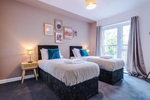 two beds in a room with a window at Formby Village Apartments By Greenstay Serviced Accommodation - Perfect For LONG STAYS - Couples, Families, Business Travellers & Contractors All Welcome - 7 in Formby