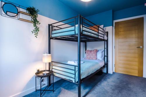 a black bunk bed in a room with a side table at Formby Village Apartments By Greenstay Serviced Accommodation - Perfect For SHORT & LONG STAYS - Couples, Friends, Families & Business Travellers All Welcome - Dog Friendly - 7 in Formby