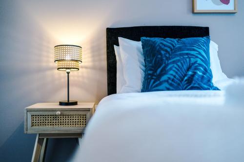 a bedroom with a bed and a lamp on a night stand at Stunning 2 Bed Apt By Greenstay Serviced Accommodation - Perfect For SHORT & LONG STAYS - Couples, Families, Business Travellers & Contractors All Welcome - 7 in Formby
