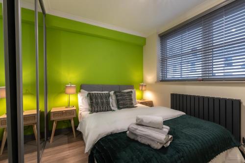 a green bedroom with a bed and a green wall at Bedford Road in Reading