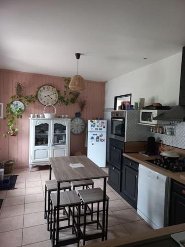 a kitchen with a table and chairs in it at Maison avec piscine proche des thermes in Mauléon-dʼArmagnac