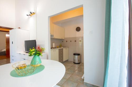 Pokój ze stołem z wazonem kwiatów w obiekcie Apartments Ela w Novalji