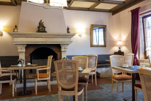 a room with tables and chairs and a fireplace at Parc Hôtel in Wangenbourg