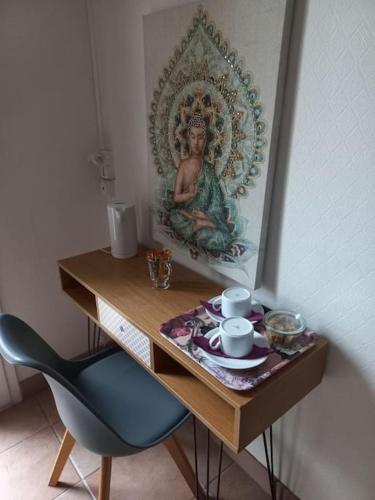 a desk with a painting of a buddha on the wall at Maison avec piscine proche des thermes in Mauléon-dʼArmagnac
