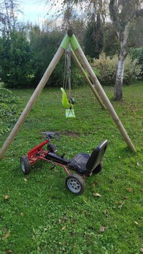 a small red tricycle parked in the grass at GITE AU PETIT RUISSEAU-Etage et combles-maison alsacienne 4 personnes 4 nuitées minimum in Langensoultzbach