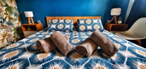 un letto blu e bianco con cuscini sopra di Disneyland cosy Apartment a Montévrain