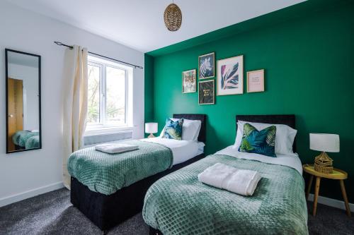 two beds in a room with green walls at Luxury 2 Bedroom Apartment With FREE Parking In Formby Village By Greenstay Serviced Accommodation - Perfect for Couples, Families & Business Travellers in Formby