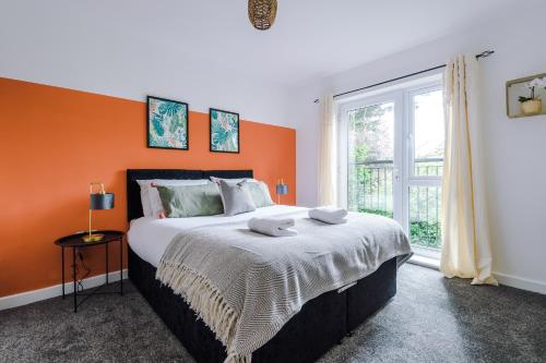 a bedroom with a large bed with an orange wall at Cosy 2 Bedroom Apartment with FREE Parking In Formby Village By Greenstay Serviced Accommodation - Ideal for Couples, Families & Business Travellers - 6 in Formby