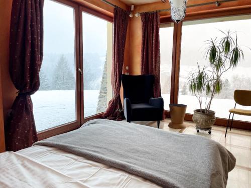 ヴィスワにあるTop Mountain Villaのベッドルーム1室(ベッド1台、椅子、窓付)