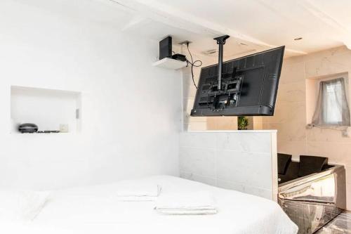 sala de estar con TV en la pared en Studio balnéo - Centre-ville, en Chalon-sur-Saône