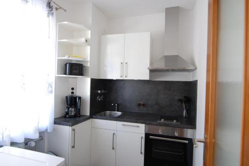 a kitchen with white cabinets and a black counter top at Apartment Reichenhall in Bad Reichenhall