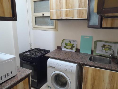 a kitchen with a washing machine and a stove at Charming 2-Bed Apartment in el zahabiazahabia in Hurghada
