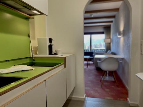 eine Küche mit einer grünen Arbeitsplatte und einem Schreibtisch in der Unterkunft Sonnhof Apartments Tegernsee - zentral und perfekt für Urlaub & Arbeit in Bad Wiessee