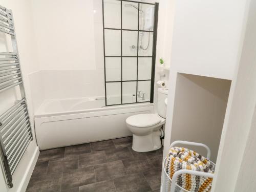 a bathroom with a tub and a toilet and a sink at Primrose in Holsworthy