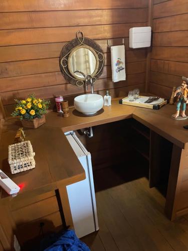 a bathroom with a sink and a mirror on a counter at Pousada BANGALÔS SOL DE LAGOINHA in Lagoinha