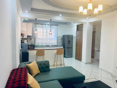 a living room with a couch and a kitchen at Arabel Studio Apartment in Nanyuki