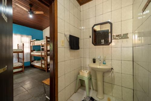 a bathroom with a sink and a mirror at Hostel Papagaio in Abraão