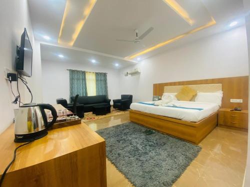 a hotel room with a bed and a desk with a phone at Shree R.C.VATIKA in Motīhāri