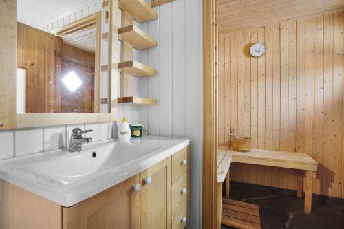 a bathroom with a sink and a wooden wall at Fairytale STAYcation 
