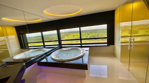 two sinks in a bathroom with two windows at Hd Park Hotel in Assis