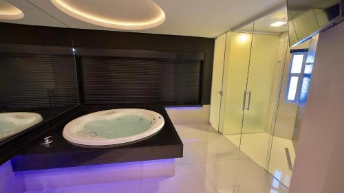 a bathroom with two sinks and a bath tub at Hd Park Hotel in Assis