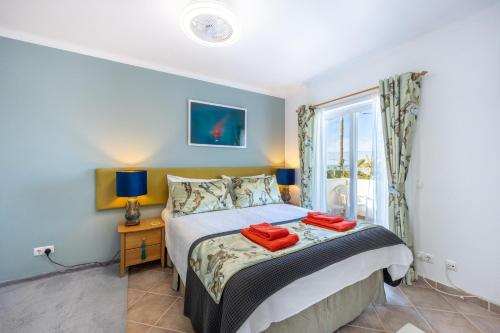- une chambre avec un lit et 2 serviettes rouges dans l'établissement Casa Da Bauhinia, à Aljezur