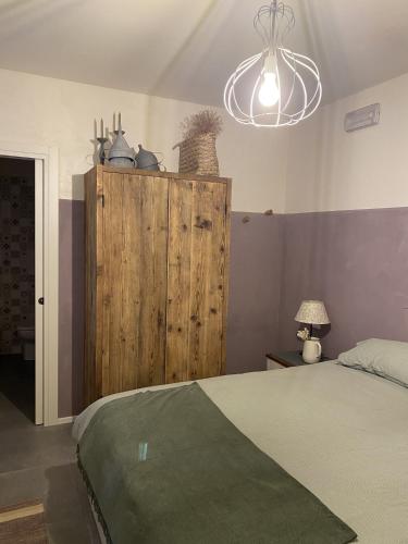 a bedroom with a bed and a wooden cabinet at B&B MELLONI STREET in Dolo