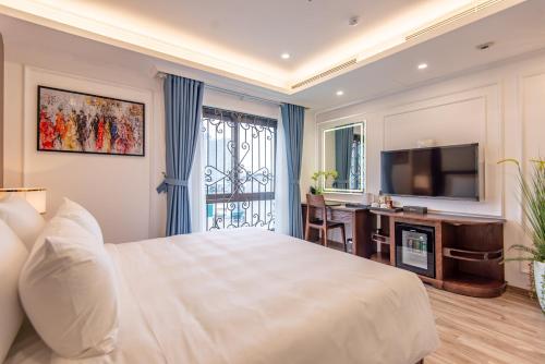 um quarto de hotel com uma cama grande e uma televisão em Reyna Luxury Hotel em Hanói