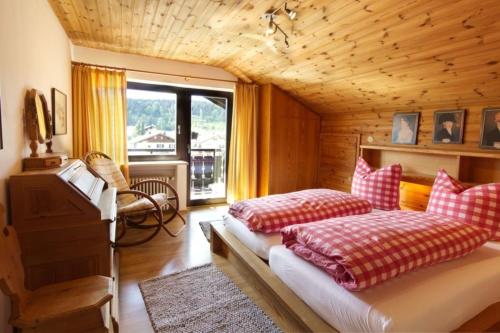 um quarto com 2 camas, uma cadeira e uma janela em Wettersteinpanorama - a74054 em Mittenwald
