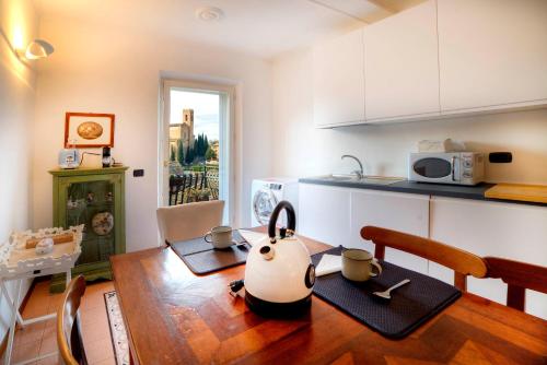 eine Küche mit einem Tisch und einer Teekanne darauf in der Unterkunft Dama charming apartment 100m from Piazza del Campo in Siena